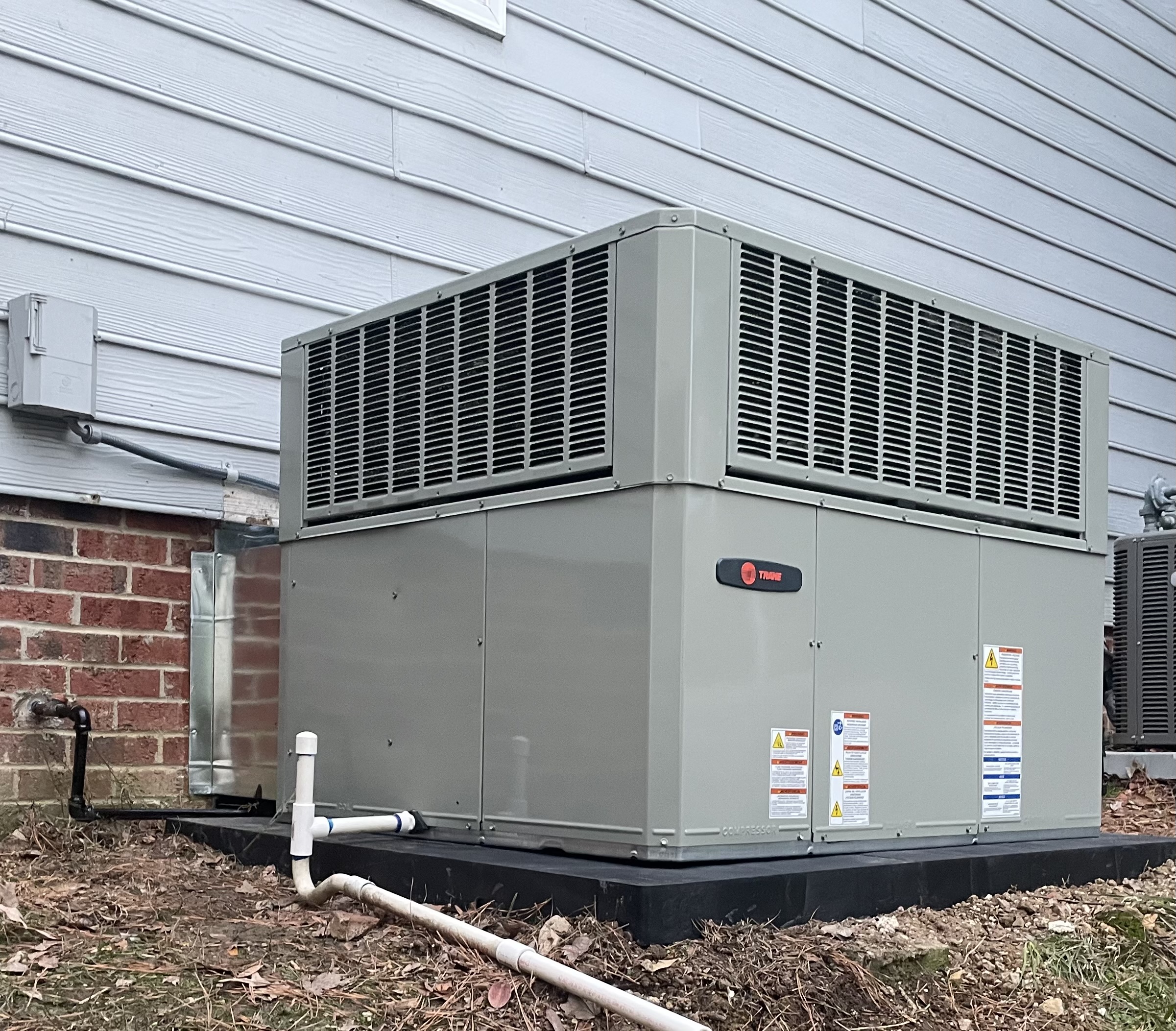 Trane packaged HVAC unit installed beside a home